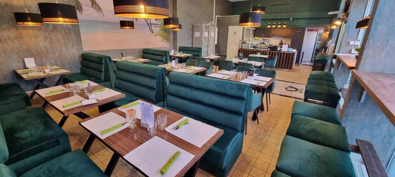 Full restaurant with green napkins and bar