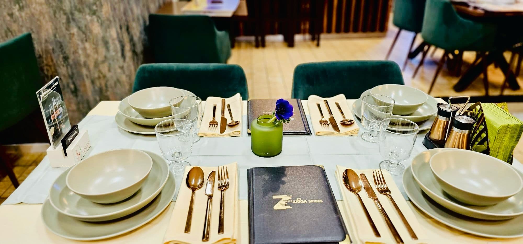 Table set with gold cutlery and sage plates